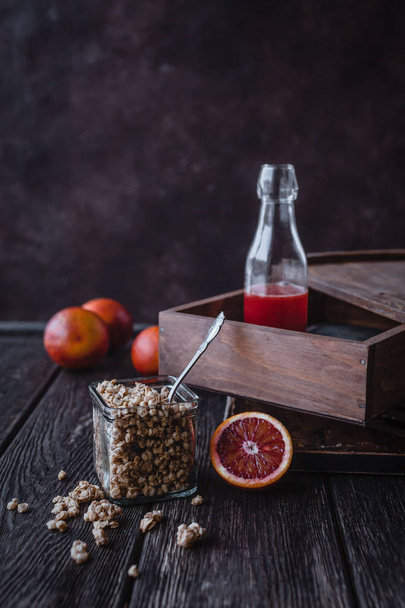 close up view of granola and fresh pomegranates fruit on wooden tabletop - Foto, imagen