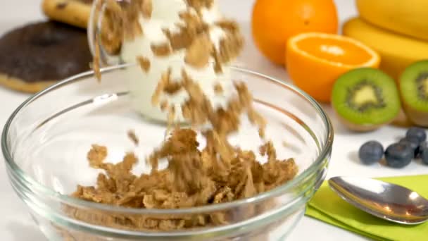 Płatki zbóż objętych w szklanej misce na zdrowe i ekologiczne śniadanie. Slow motion shot. - Materiał filmowy, wideo