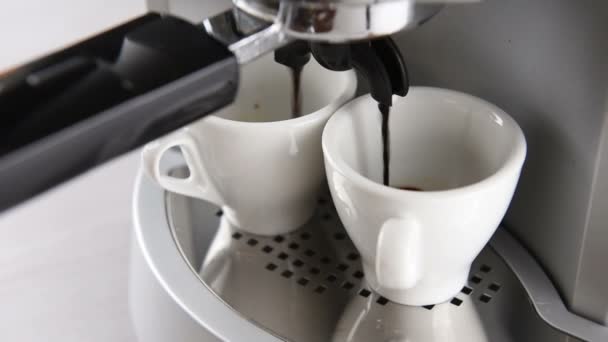 koffiezetapparaat ingebruikzijn vult twee witte kopje koffie. Clip met cirkelvormige beweging schieten. - Video