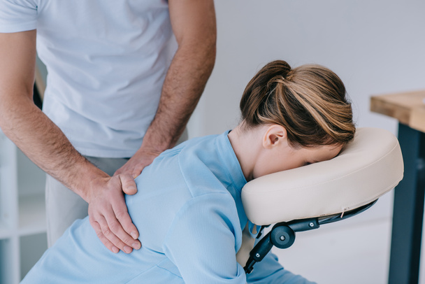 primo piano colpo di massaggiatore massaggiando indietro di cliente femminile
 - Foto, immagini