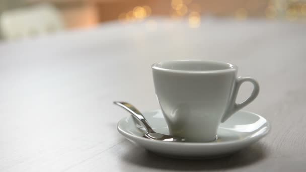 Kofeina, zalewanie czarnej kawy kubek na stole. Strzelanie z ruchem okrężnym - Materiał filmowy, wideo