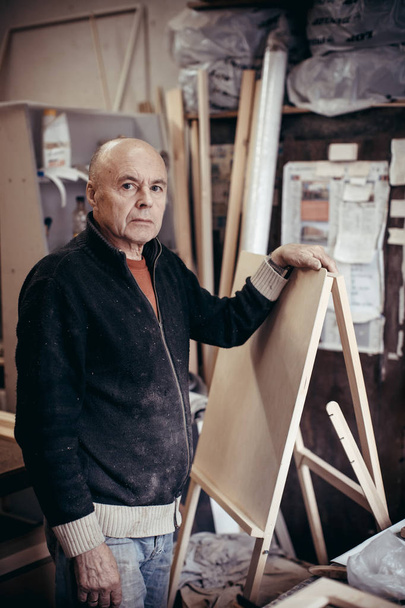 Portrait of a carpenter with a new easel. - 写真・画像