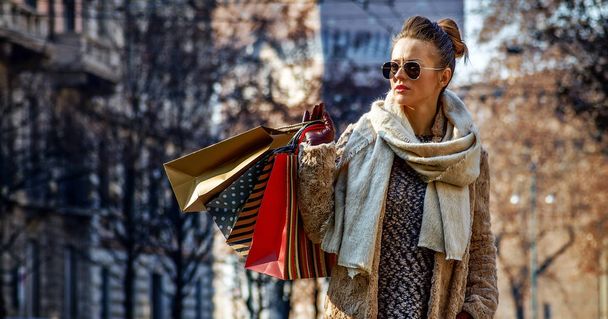 Redescubrir cosas que todo el mundo ama en Milán. Retrato de larga duración de una joven viajera con bolsas de compras en Milán, Italia mirando a la distancia
 - Foto, Imagen