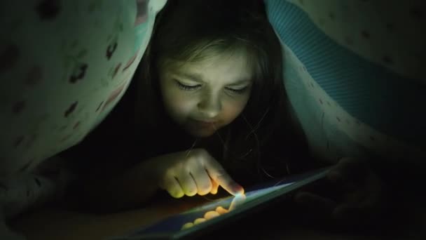 Ένα κορίτσι δέκα ετών χρησιμοποιεί ένα δισκίο το βράδυ - Πλάνα, βίντεο