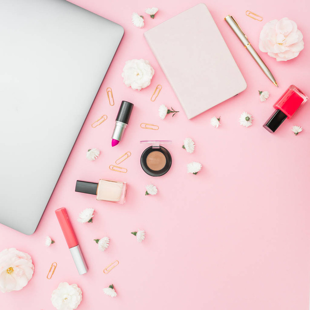 Top view of cosmetic products, stationary and flowers on pink background - Photo, Image