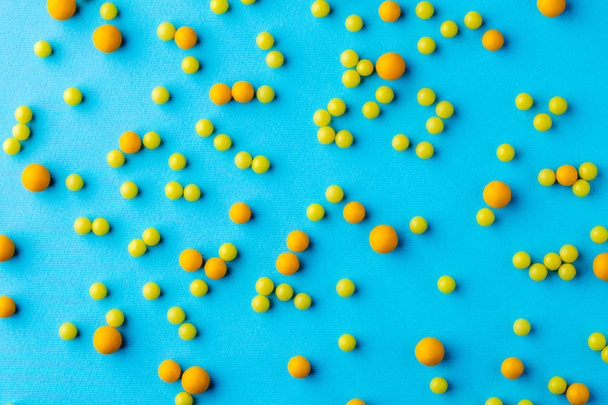 Many yellow pills on blue background - Zdjęcie, obraz