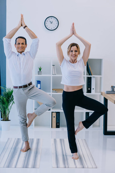 podnikatel s jeho trenér cvičení jógy v stromu představují na kancelář - Fotografie, Obrázek