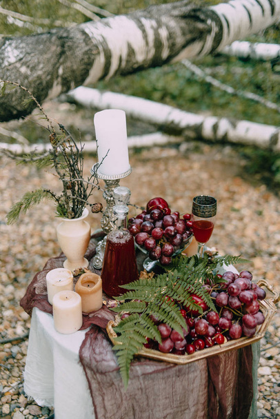 Fruit and berries on a table with candles - Фото, зображення