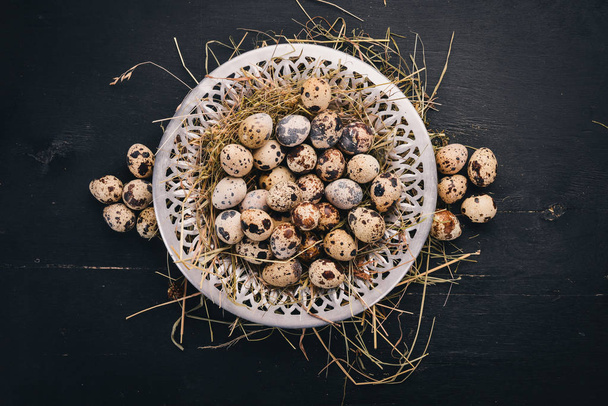 Quail eggs in a metal plate. On a wooden background. Top view. Copy space. - Valokuva, kuva