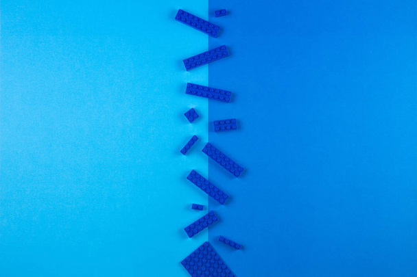 Toys background. Plastic construction blocks on blue background - Photo, Image