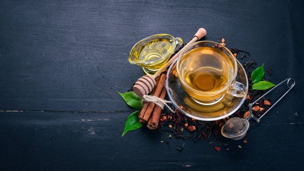 Tea in a cup of cinnamon and honey on a wooden background. Hot drink Top view. Copy space. - Foto, Imagem