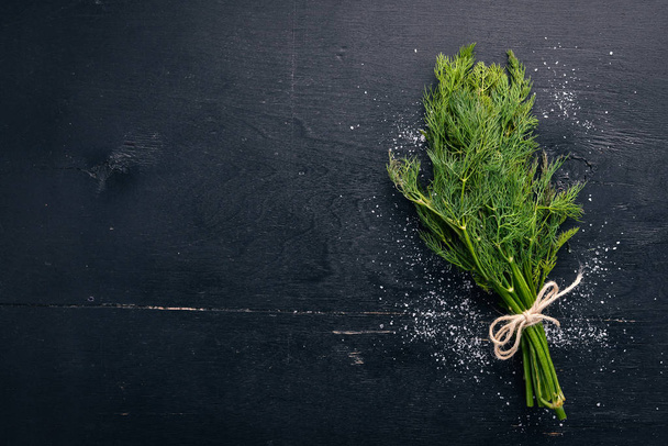 Fresh green dill on a wooden background. Top view. Free space for your text. - 写真・画像