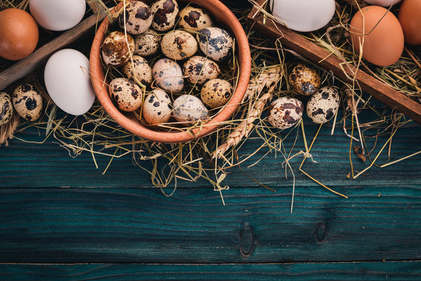 A set of chicken and quail eggs. On a wooden background. Top view. Copy space. - Zdjęcie, obraz
