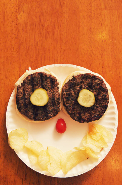 Un hamburger arrangé pour faire un visage humain
. - Photo, image