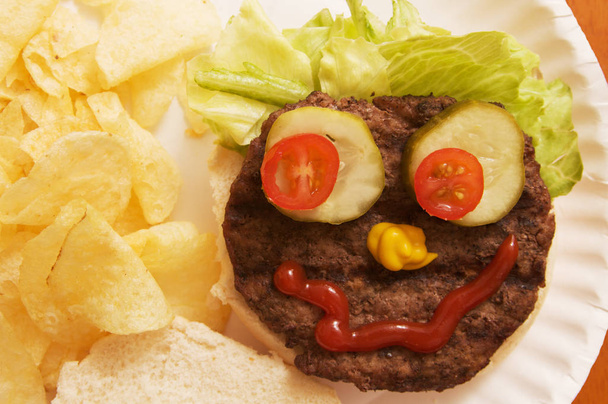 A hamburger arranged to make a human face. - Photo, Image