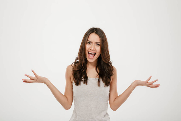 Picture of Angry brunette woman screaming and looking at camera - Фото, изображение