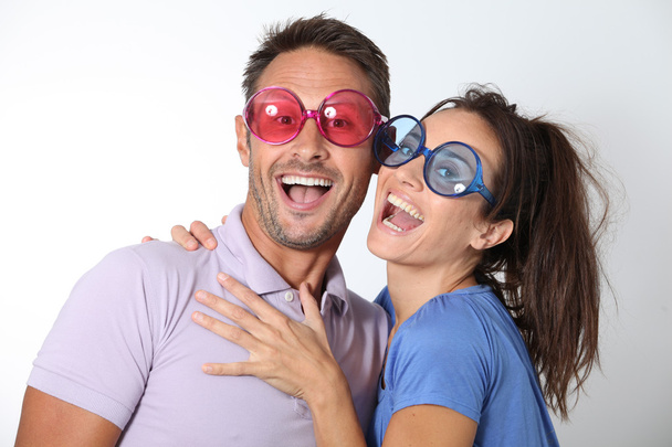 Couple wearing colored glasses having fun - Foto, afbeelding
