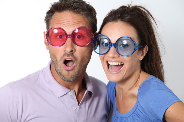 Couple wearing colored glasses having fun - Fotó, kép
