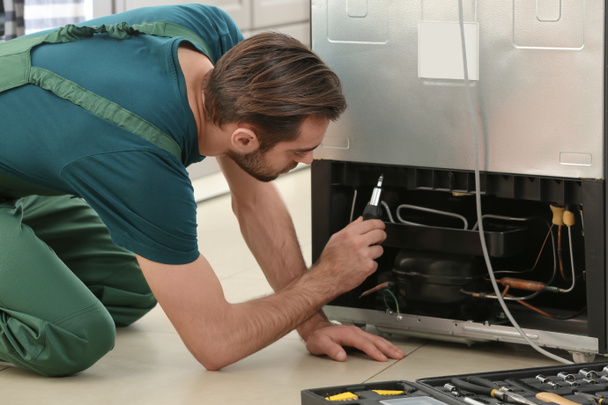 Erkek teknisyen tamir buzdolabı kapalı - Fotoğraf, Görsel