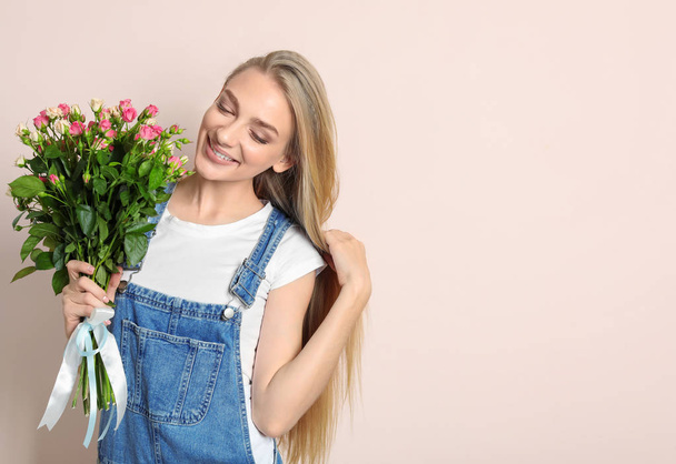 Beautiful young woman with bouquet of roses on color background - Fotoğraf, Görsel