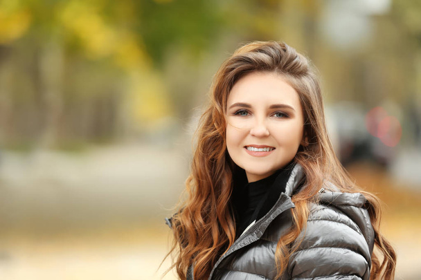 Beautiful smiling woman in puffer jacket outdoors - Foto, Bild