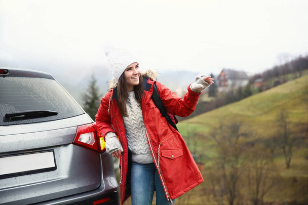 Female tourist standing near car in countryside - Photo, Image