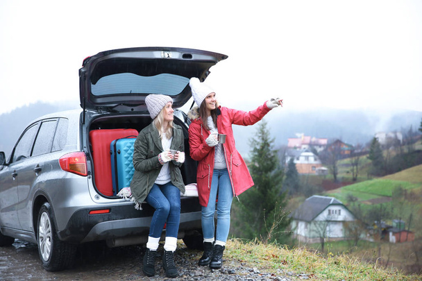 Female tourists near car in countryside - Foto, Imagem