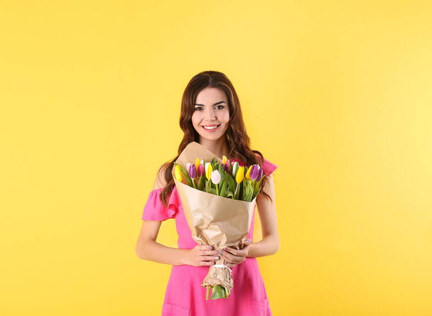 Beautiful woman holding bouquet of tulips on color background - Φωτογραφία, εικόνα