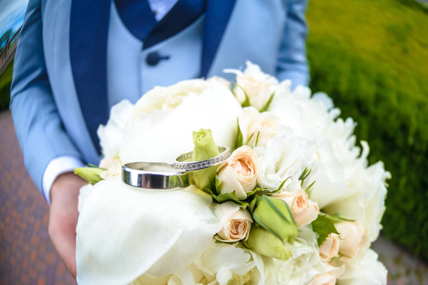 alliances reposent sur un beau bouquet comme accessoires de mariée - Photo, image
