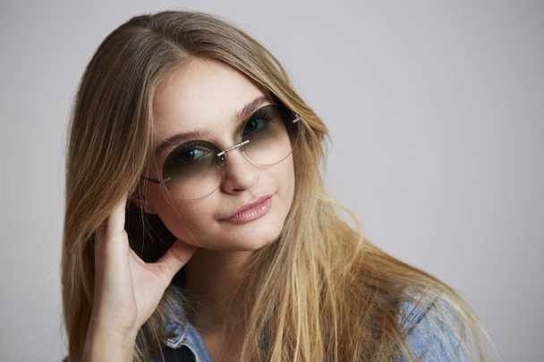 Cool young woman smiling in shades - Foto, afbeelding