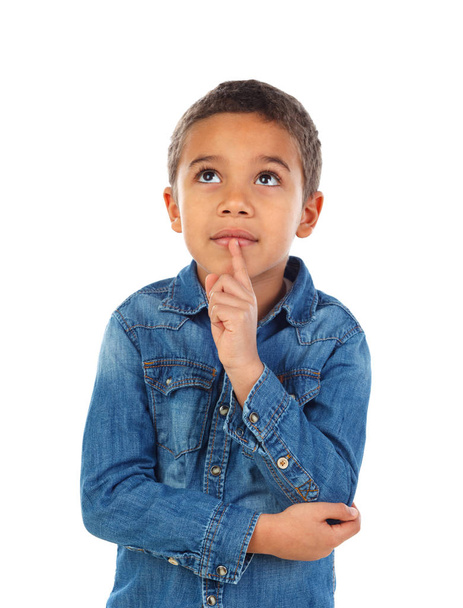 cute little African boy in denim shirt with forefinger at his lips as sign of silence, isolated on white background - 写真・画像