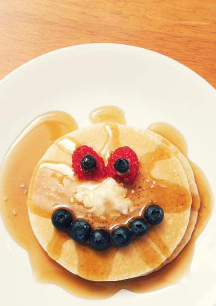 ein Pfannkuchenfrühstück arrangiert, um wie ein Gesicht auszusehen. - Foto, Bild