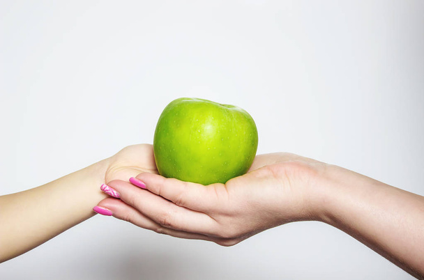 Green apple in hands. Selective focus. - Φωτογραφία, εικόνα