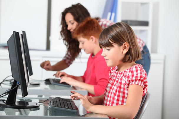 Teacher and children learning to use computer - Foto, Bild