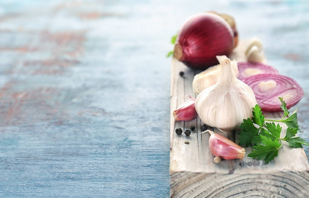 Fresh garlic and onion on color background, closeup - Foto, afbeelding