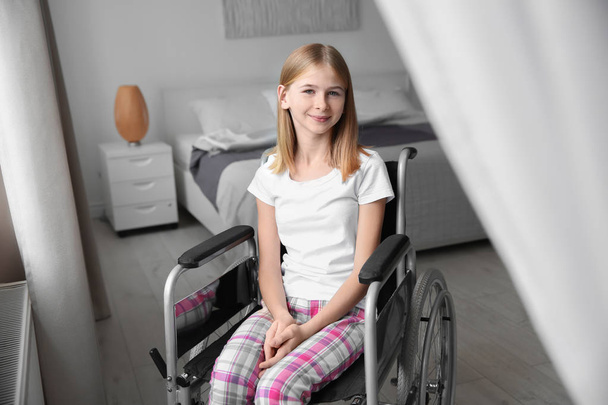 Teenage girl in wheelchair indoors - 写真・画像