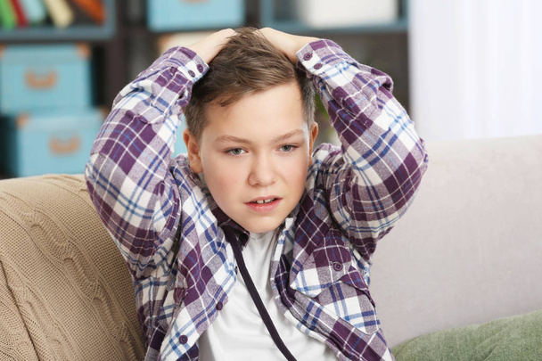 Upset teenage boy in casual clothes indoors - Foto, imagen
