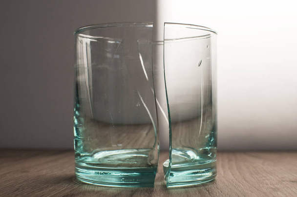Tazza di vetro trasparente rotto in due parti simmetriche primo piano
 - Foto, immagini