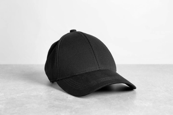Black cap on table against white background. Mockup for design - Foto, Imagen
