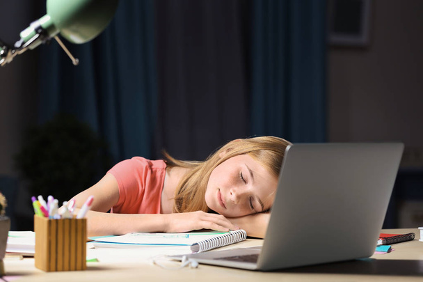 Adolescente que se queda dormido mientras hace la tarea en la mesa por la noche
 - Foto, imagen