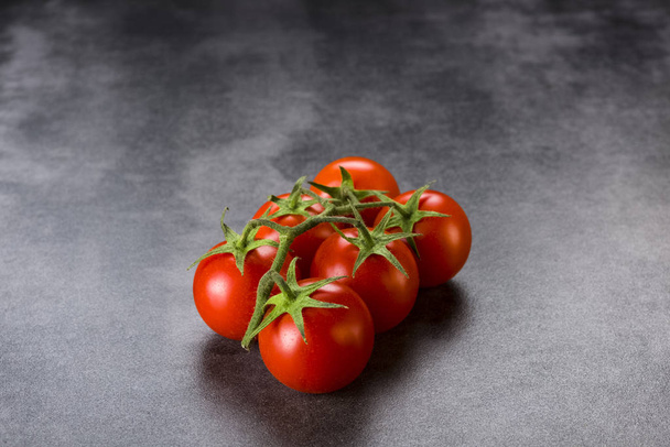 twig with tomatoes on a stone foundation  - Photo, image