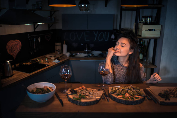 Young woman with closed eyes sits at the table with food - Photo, Image