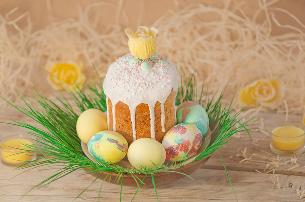 Pastel and colorful easter eggs and Easter cake. Easter eggs painted in pastel colors lying on the meadow - Foto, afbeelding