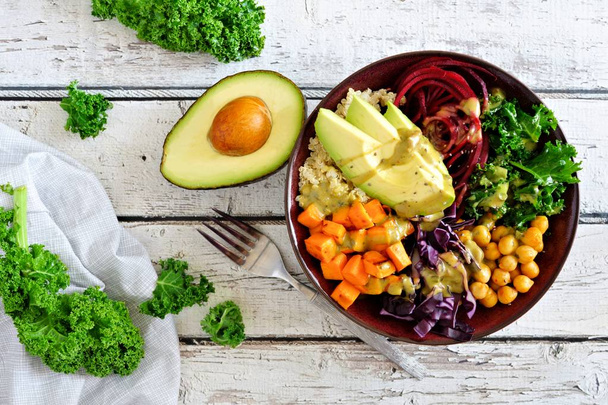 Buddha bowl met quinoa, avocado, kikkererwten, groenten op een witte achtergrond van hout. Gezonde voeding-concept. Bovenaanzicht. - Foto, afbeelding