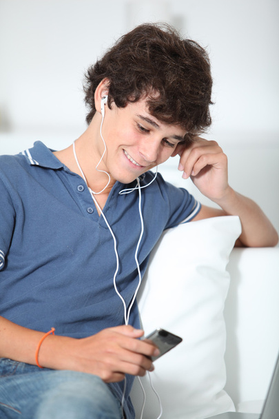 Teenager listening to music with mp3 player - 写真・画像