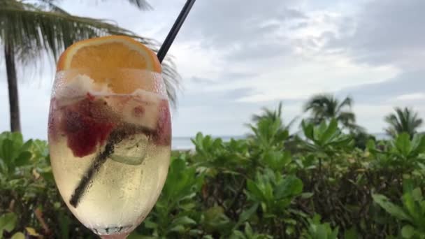 White sangria with strawberry, orange and apple outside the tropical restaurant. Bali island. Sangria on a tropical background. - Video, Çekim
