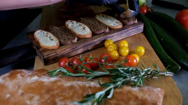 Man preparing Italian bruschetta with baked tomatoes, basil and cheese. Italian food slow motion - Metraje, vídeo