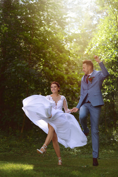 The bride and groom are having fun in the woods - Φωτογραφία, εικόνα