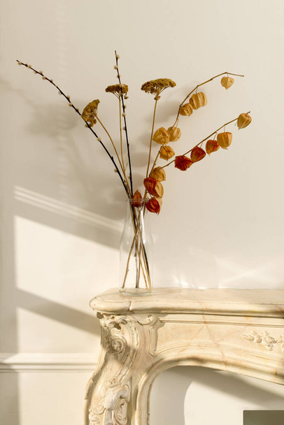 Tiszta üveg váza virág hervadt virágzik a kandalló - Fotó, kép
