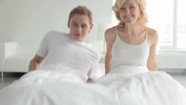 uśmiechający się para w łóżku - Materiał filmowy, wideo